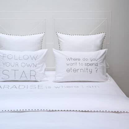 Hand-embroidered quotes on white bed linen with black thread