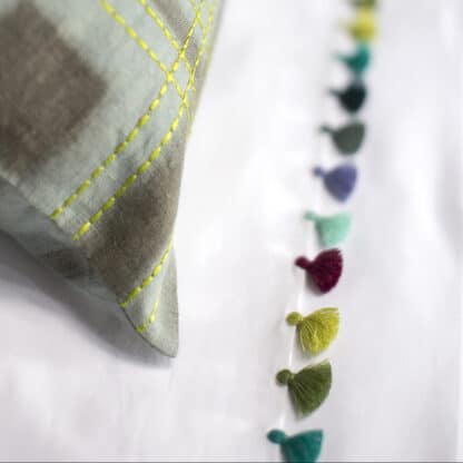 Bed linen with multicolor pompoms in casapiedra color,