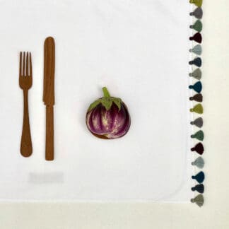 linge de table blanc aux pompons multicolores